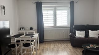 Wohnzimmer der Wohnung 1 mit Essplatz und Sofa