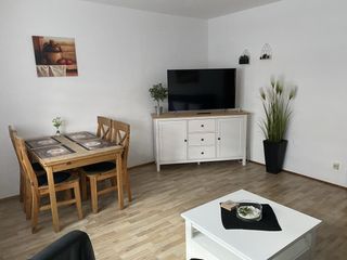 Wohnzimmer der Wohnung 1, Essplatz mit TV-Kommode