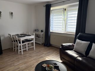 Wohnzimmer der Wohnung 1 mit Essplatz und Sofa