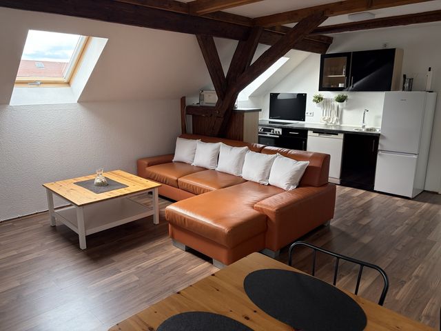 Wohnbereich mit Sofa und offener Küche
