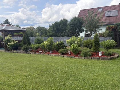 Blumenbeet mit Deko-Figuren am Gartenzaun