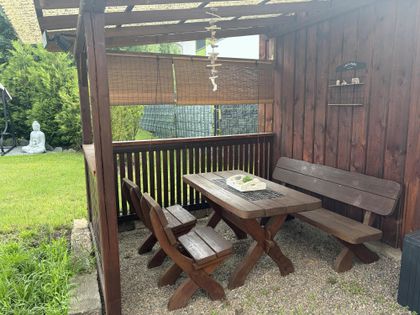 Gemütlicher Sitzplatz im überdachten Gartenhaus